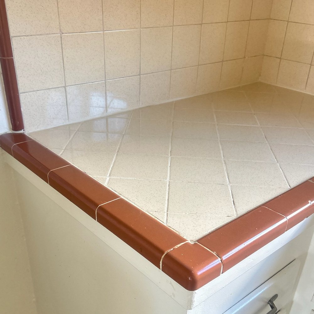 Tiled kitchen counter before and after a deep clean — after