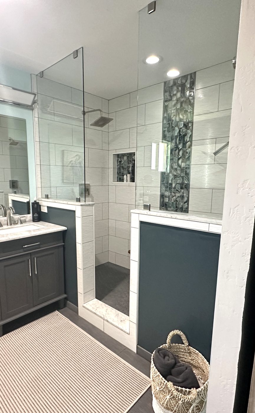 Guest bathroom with glass shower and mosaic tile after cleaning