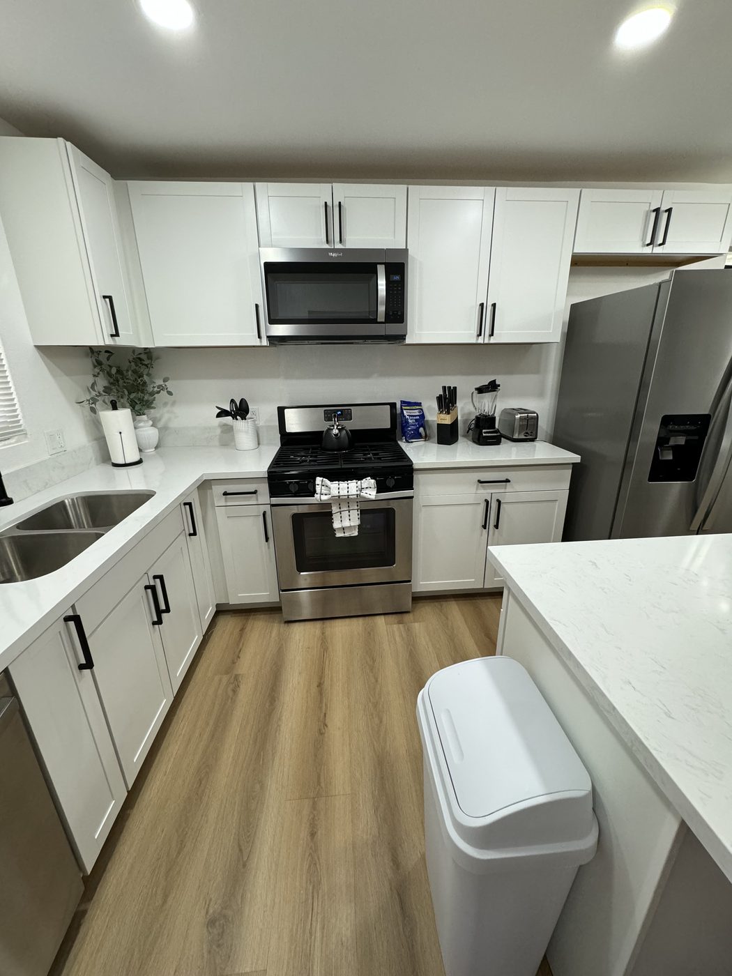 White kitchen with gas range and stainless appliances after cleaning